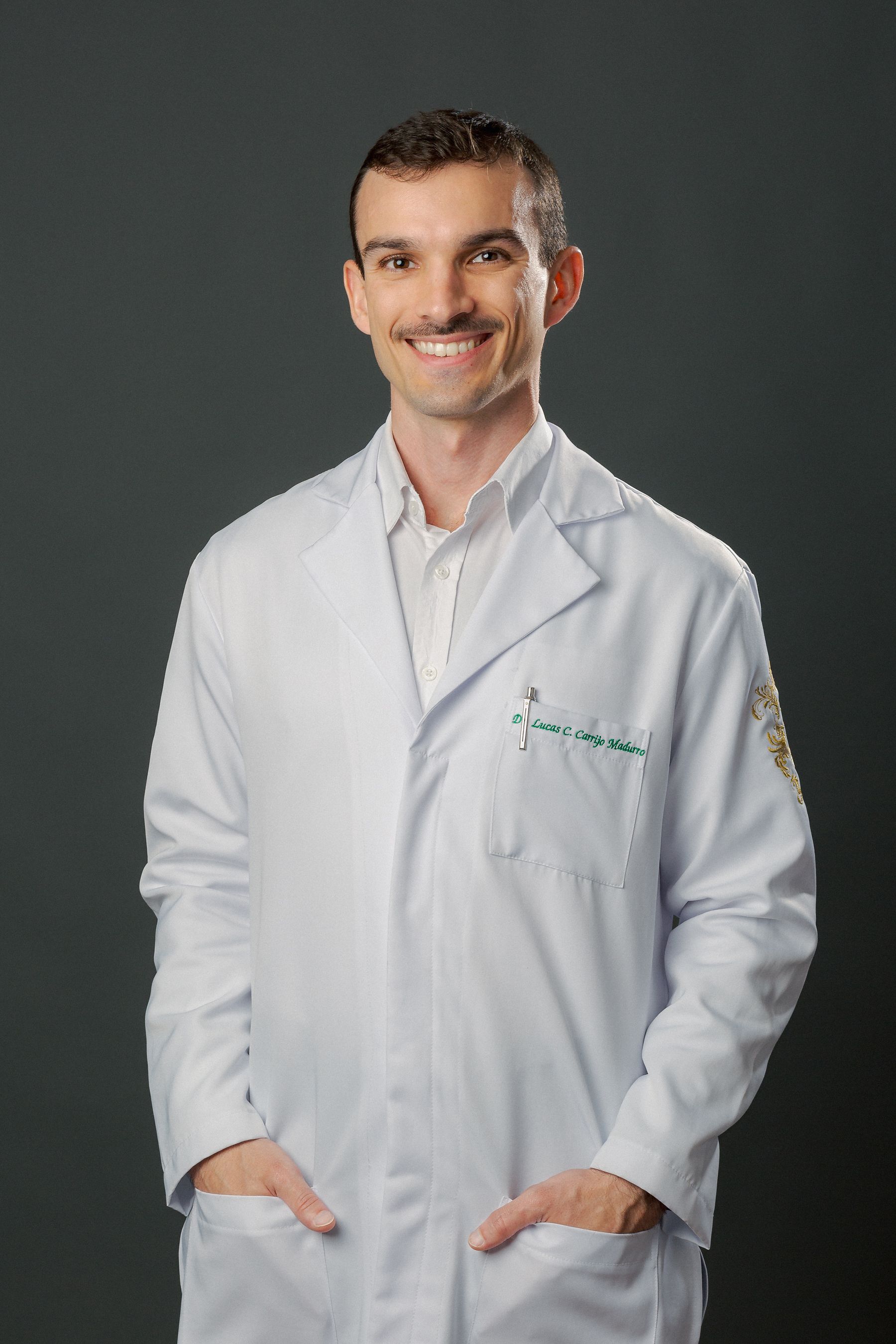 Dr. Lucas Carvalho de jaleco branco, sorrindo