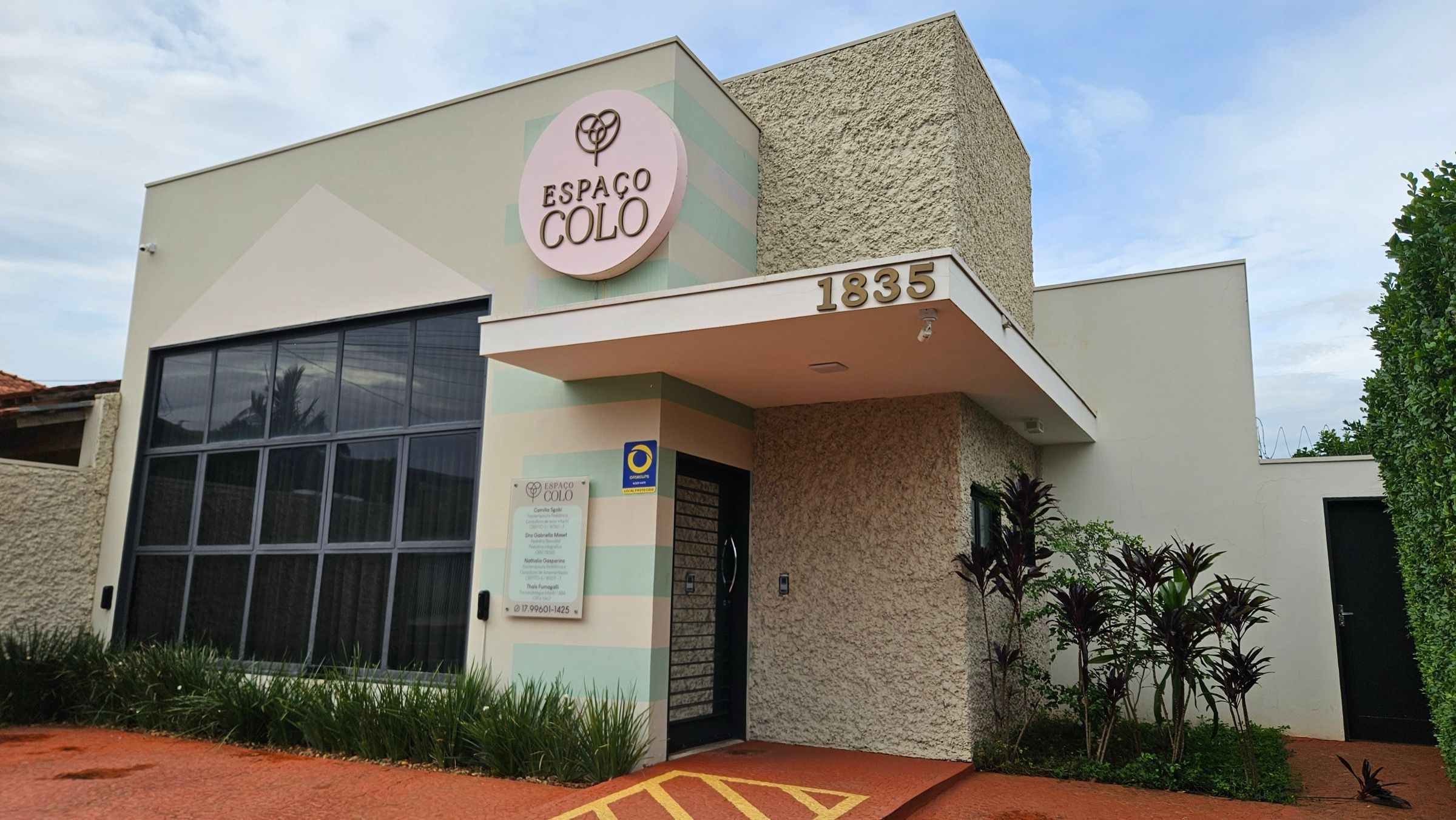 Fachada do Espaço Colo, número 1835 da Rua Bonfá Natale, com placa redonda rosa na parede