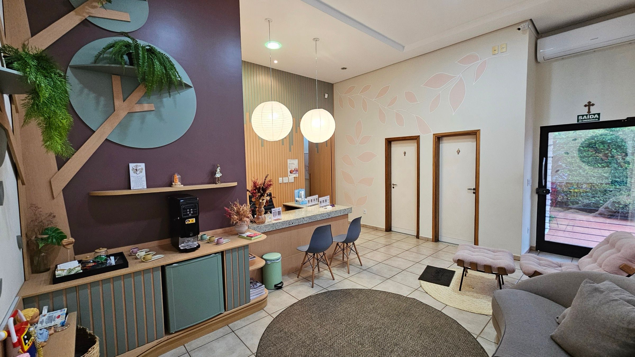 Sala de espera do Espaço Colo, com cantinho do café e porta para o jardim